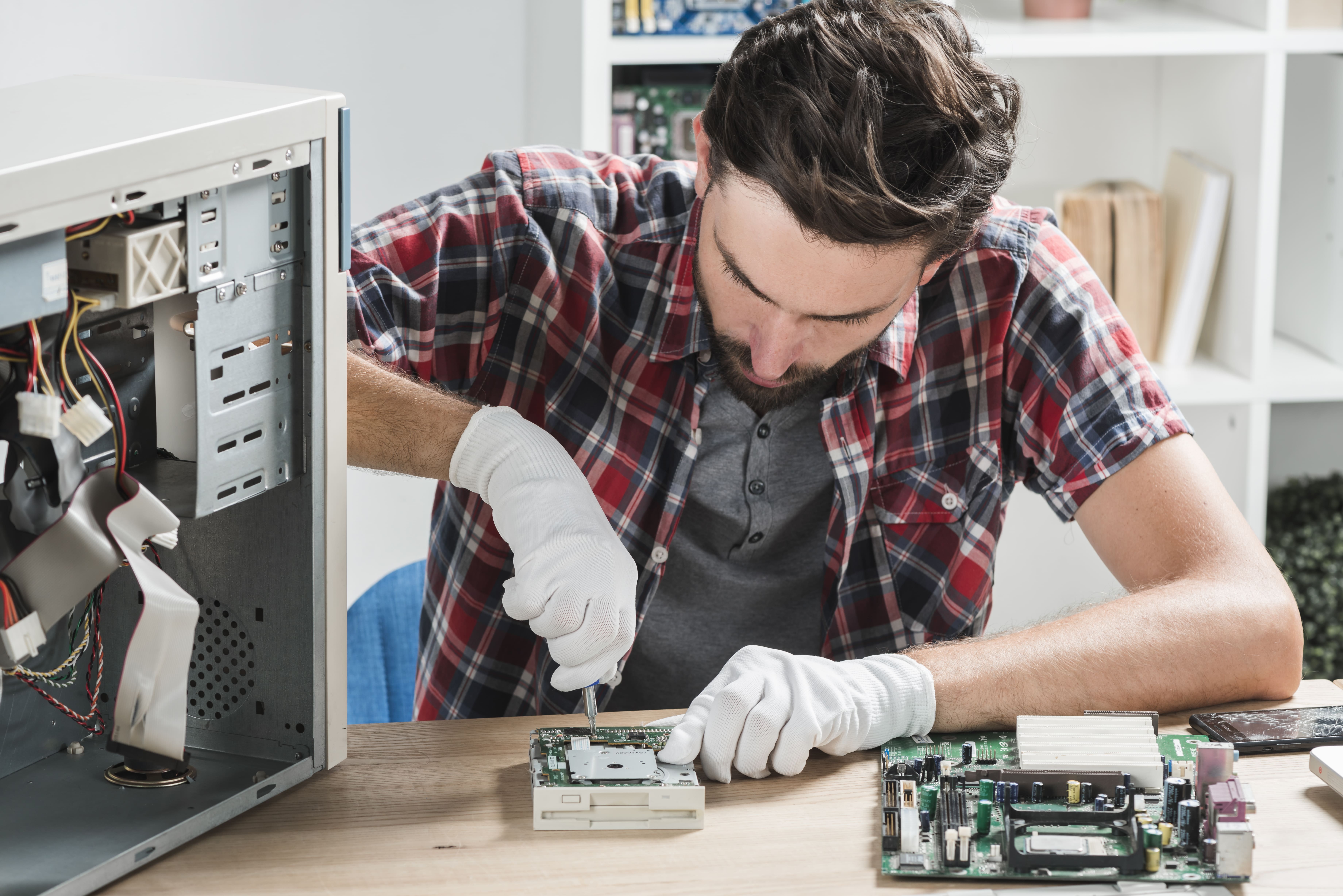 young-male-technician-wearing-gloves-fixing-computer-motherboard-with-screwdriver.jpg